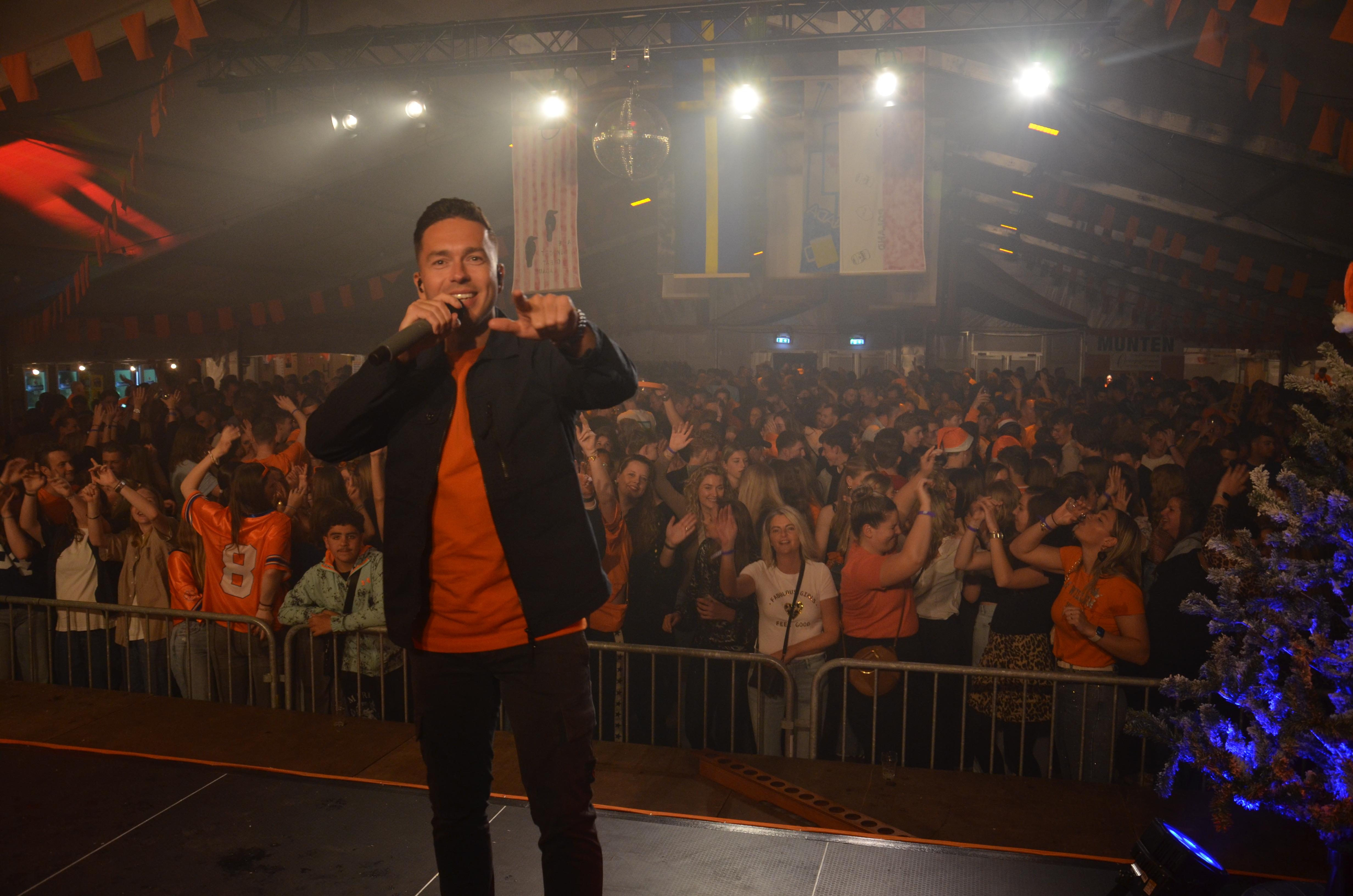 Artiest op podium met publiek op festival